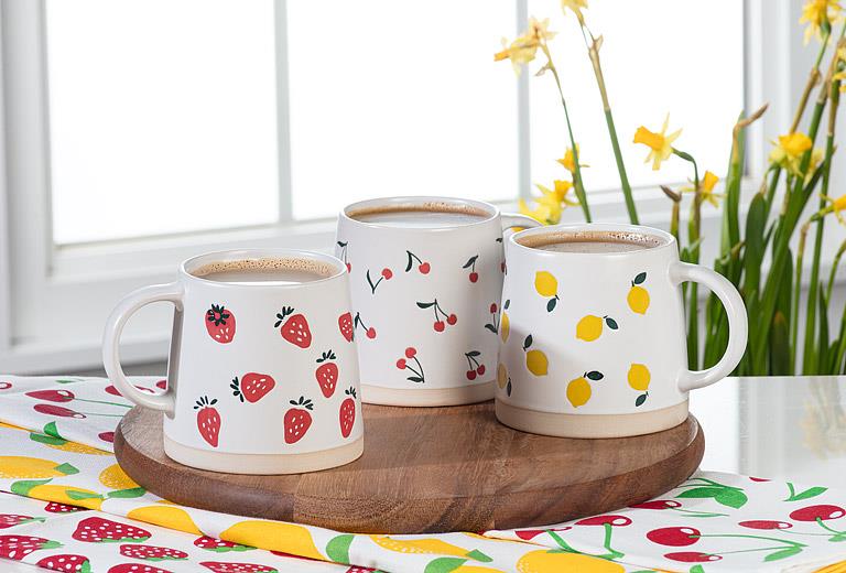 Abbott lemon stoneware mugs displayed on a tray with spring flowers and colorful table décor