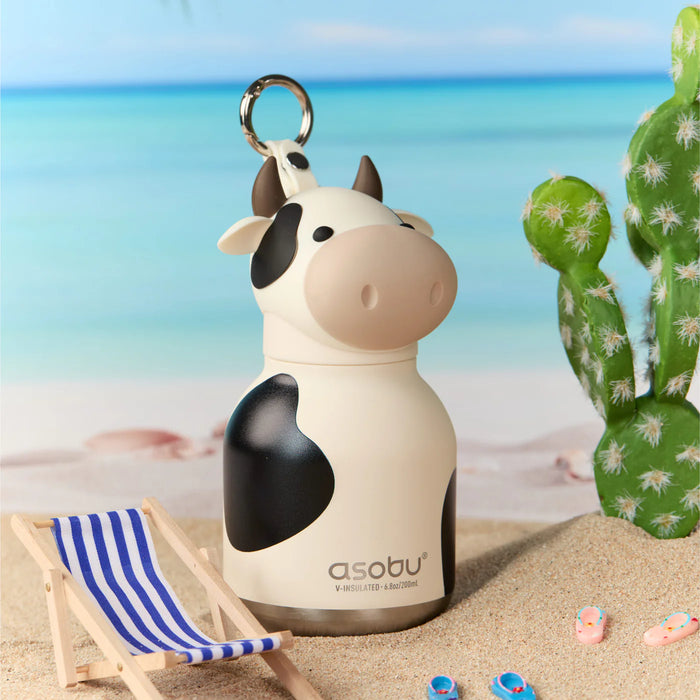 Asobu Mini Cow Bestie insulated water bottle displayed on a beach with summer accessories