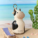 Asobu Mini Cow Bestie insulated water bottle displayed on a beach with summer accessories