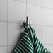 Buster + Punch Cast hook in steel finish holding towel in modern bathroom