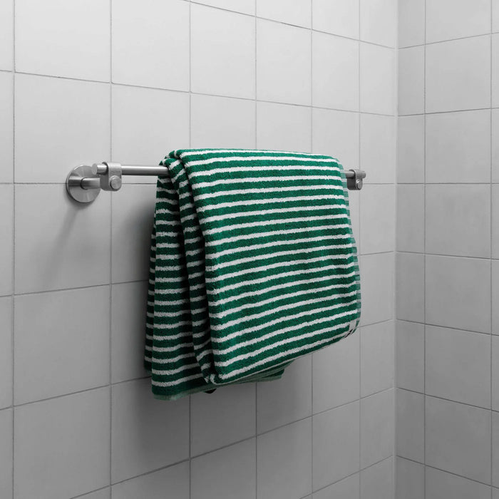 Installed Buster + Punch Cast medium towel rail in steel finish with striped towel