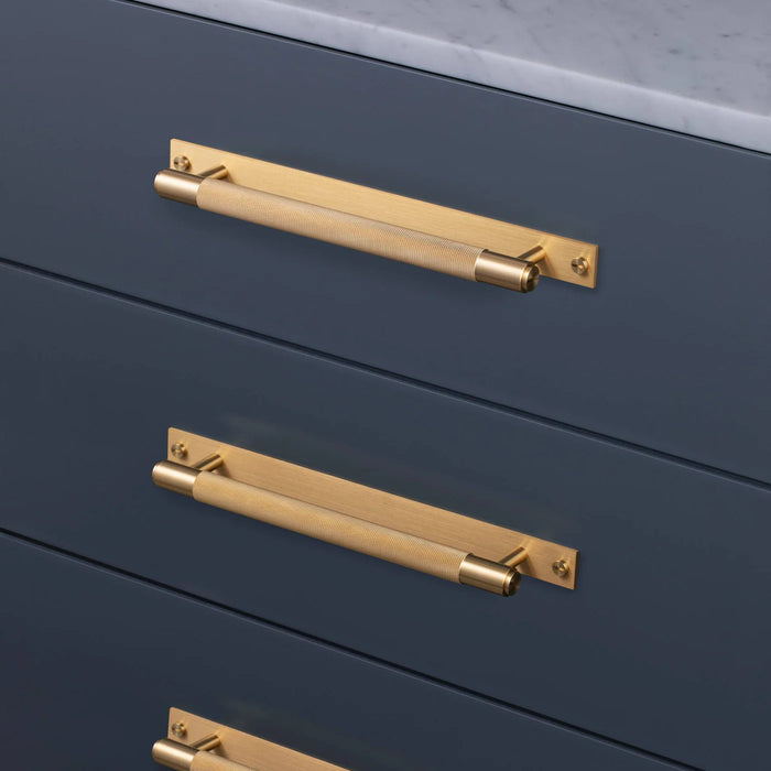 Brass Buster + Punch Cross Pull Bar with Backplate installed on luxury cabinetry medium size
