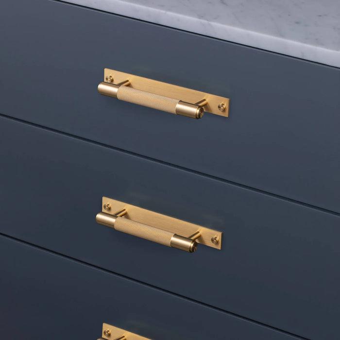 Brass Buster + Punch Cross Pull Bar with Backplate installed on modern cabinet drawers small size