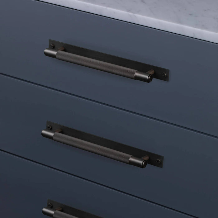 Smoked Bronze Buster + Punch Cross Pull Bar with Backplate installed on modern cabinetry