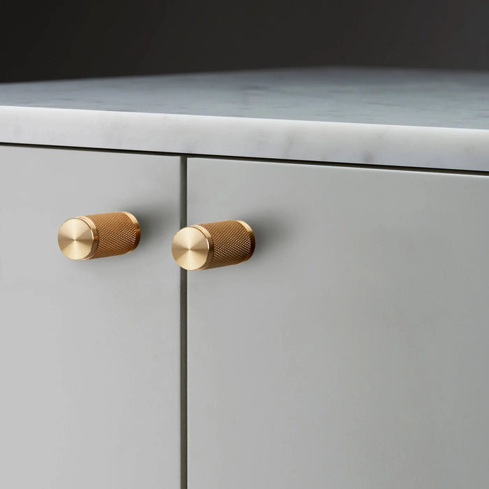 Buster + Punch Furniture Knob Cross in brass finish mounted on cabinetry