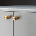 Buster + Punch Furniture Knob Cross in brass finish mounted on cabinetry