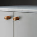 Buster + Punch Furniture Knob Cross in warm sunset finish installed on cabinet doors