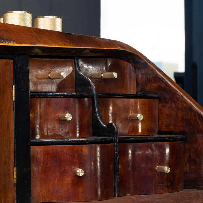 Close-up of Buster + Punch Linear Brass furniture knobs on dark wood cabinetry