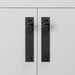 Full-length Buster + Punch Cross Black furniture knob plates on cabinetry