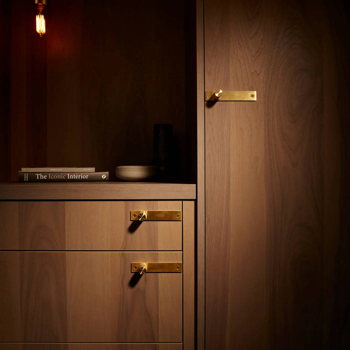 Brass Buster + Punch furniture knob plates in warm luxury interior