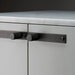Close-up of Buster + Punch Cross Smoked Bronze furniture knob plate on cabinetry