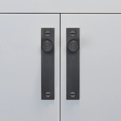 Buster + Punch Furniture Knob Plate Cross in Smoked Bronze finish on white cabinet doors