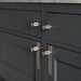 Steel Buster + Punch Cross furniture knob plates on dark cabinetry