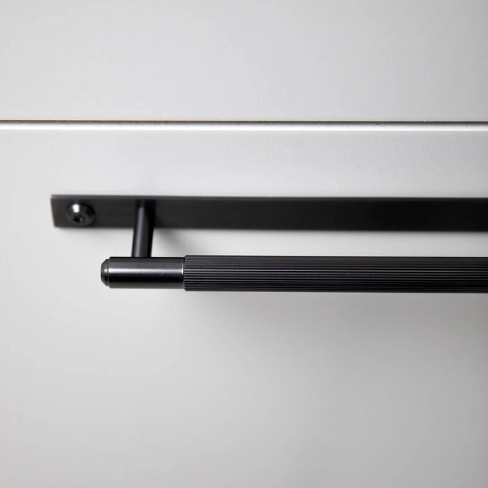 Close-up of black Buster + Punch Linear cabinet pull installed on cabinetry