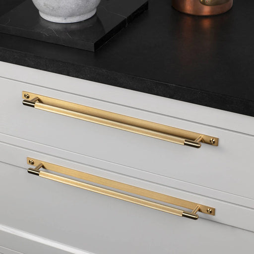 Brass Buster + Punch Linear cabinet pull installed on white drawers