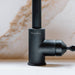 Engraved Buster + Punch logo on welder's black linear kitchen faucet