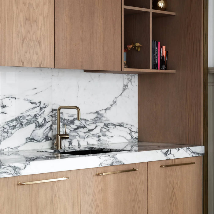 Brass Buster + Punch Linear Pull Bar handles installed on modern kitchen cabinetry