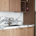 Brass Buster + Punch Linear Pull Bar handles installed on modern kitchen cabinetry