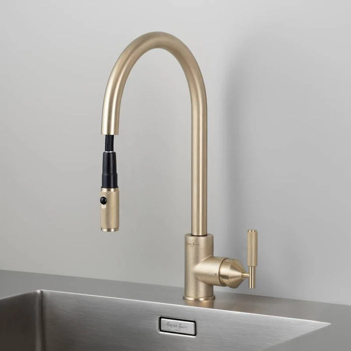 Angled view of Buster + Punch brass kitchen faucet with dual spray