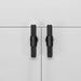 Pair of Buster + Punch T-Bar Cross cabinet knobs in Black finish mounted on cabinetry