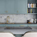 Brass Buster + Punch T-Bar Cross knobs installed in modern luxury kitchen cabinetry