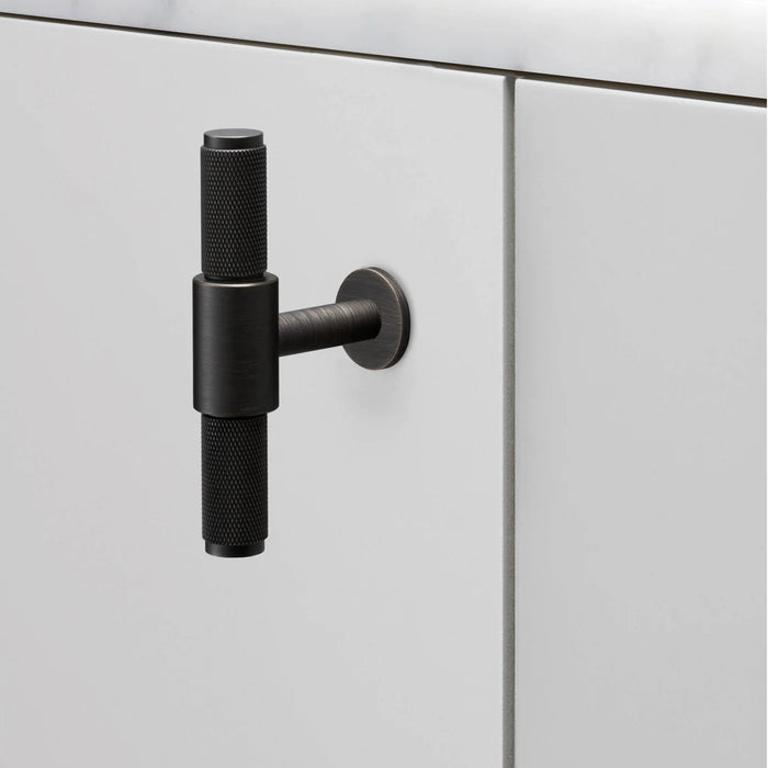 Buster + Punch T-Bar Cross cabinet knob in Smoked Bronze finish mounted on cabinetry