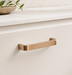 CBH 245 Square Return Bar cabinet pull in satin bronze finish installed on cream cabinetry