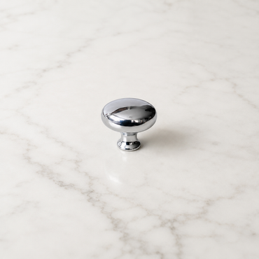 CBH 502 Classic Dome Cabinet Knob in bright chrome with rounded dome design on a white marble surface.