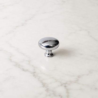 CBH 502 Classic Dome Cabinet Knob in bright chrome with rounded dome design on a white marble surface.