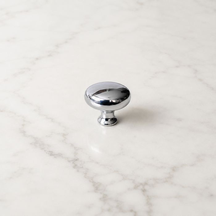 CBH 502 Classic Dome Cabinet Knob in bright chrome with rounded dome design on a white marble surface.