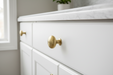 CBH 502 Classic Dome Cabinet Knob in Bright Brass installed on a white cabinet