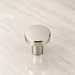 CBH 503 Minimalist Round Cabinet Knob in Bright Nickel Plated finish displayed on marble