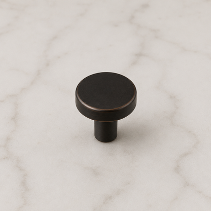 CBH 503 Minimalist Round Cabinet Knob in Clear Lacquered Oxidized Bronze finish displayed on marble