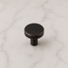 CBH 503 Minimalist Round Cabinet Knob in Clear Lacquered Oxidized Bronze finish displayed on marble