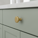CBH 503 Minimalist Round Cabinet Knob in Satin Brass finish installed on painted cabinetry