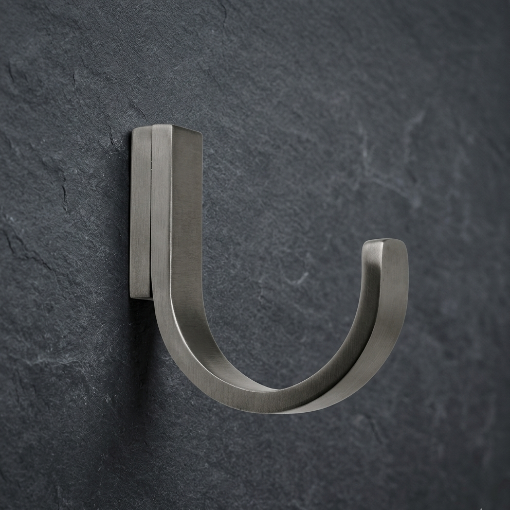 Pewter wall hook CBH 66 installed on dark wall minimalist curved coat hook
