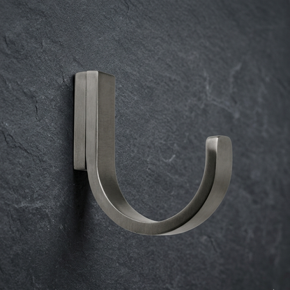 Pewter wall hook CBH 66 installed on dark wall minimalist curved coat hook