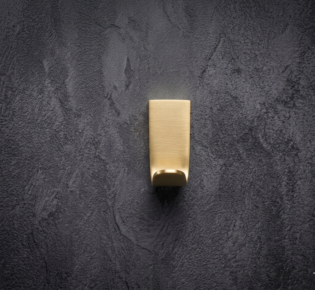 CBH 68 angled projection coat hook in satin brass finish front view on dark wall