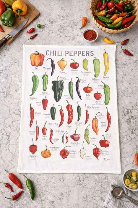 Chili peppers kitchen towel styled with fresh vegetables on kitchen countertop flat lay