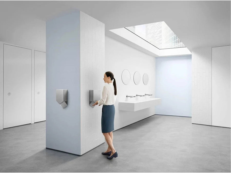 Person using Dyson Airblade V hand dryer in commercial restroom