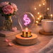 Flamingo neon LED light bulb on wooden base glowing on bedside table with cozy decor and warm lighting