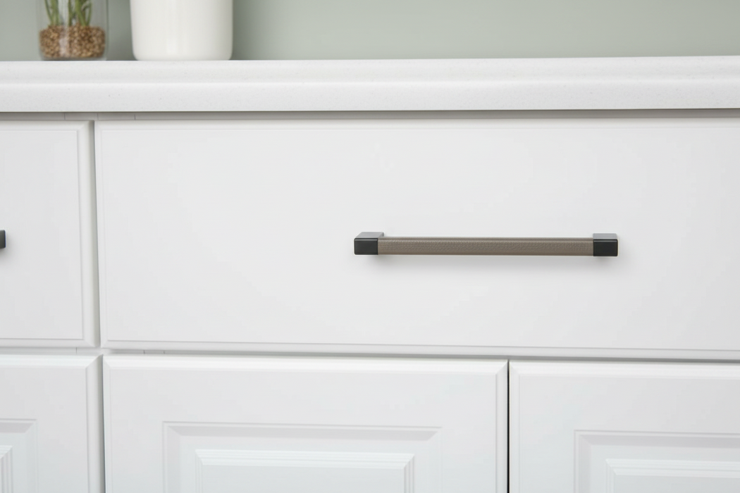 Häfele Elite Leather cabinet handle in black finish installed on a modern cabinet drawer.