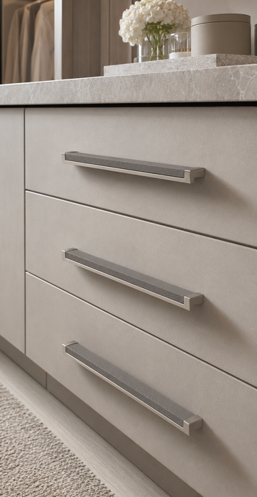 Close-up of Häfele Elite Leather cabinet handles in matte nickel finish with Pewter faux leather inserts installed on contemporary vanity drawers.