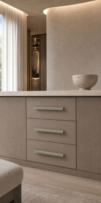Häfele Elite Leather cabinet handles in matte nickel finish with Oyster faux leather inserts installed on a modern vanity with three drawers.