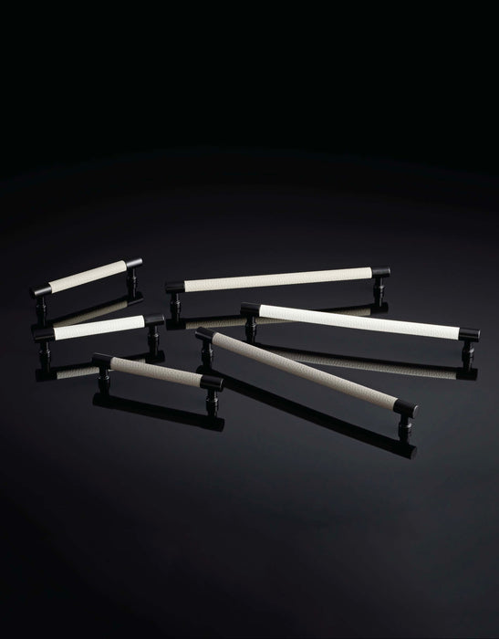 Häfele Elite Leather matte black cabinet pulls shown in Winter, Oyster, and Pewter faux leather finishes.
