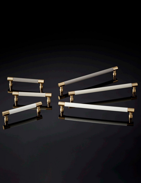 Comparison chart of Häfele Elite Leather cabinet handles in matte gold with Winter, Oyster, and Pewter faux leather finishes in 128 mm and 256 mm centre-to-centre sizes.