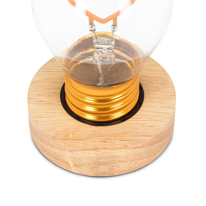 Heart LED lightbulb placed in wooden base close-up view