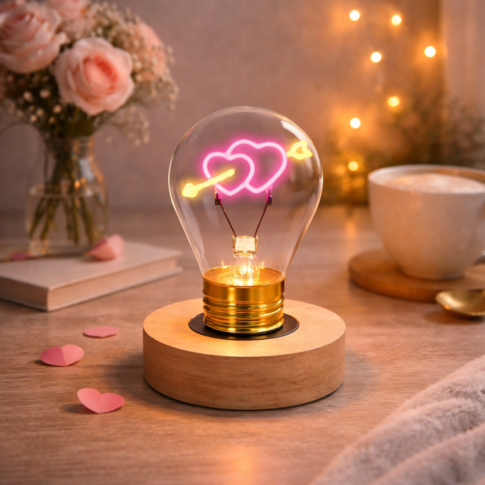 Hearts and arrow neon LED light bulb on wooden base glowing in cozy romantic room setting