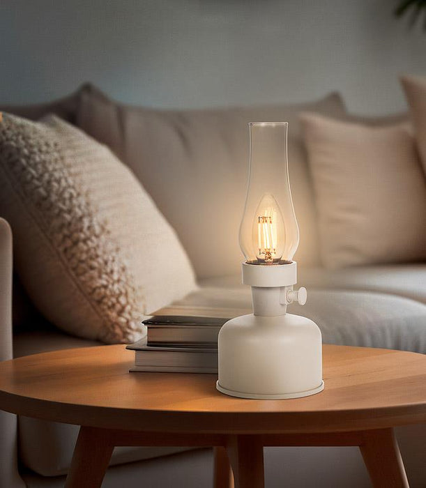 Ivory lantern LED lamp creating warm ambient lighting on a bedside table