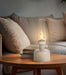 Ivory lantern LED lamp creating warm ambient lighting on a bedside table